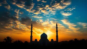 The sun sets behind a mosque in the middle of the desert photo