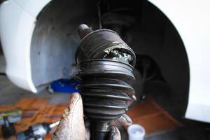 Close up of front drive axle damaged of car or CV joint photo