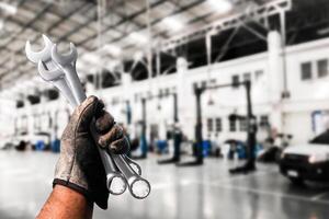 Mechanic holding wrenches in automotive workshop , Slim Open-end Wrench in mechanic hand , Automotive repair concept photo