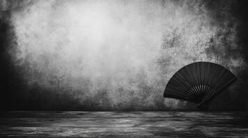 A lonely fan rests against a textured wall under dramatic light photo