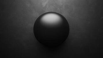 Dark sphere shaped form with a bright highlight on a textured surface photo