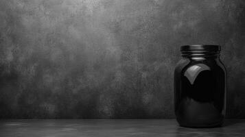 Black Glass Jar on Dark Textured Background photo