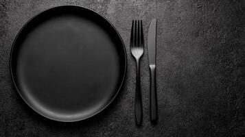 Black Plate with Cutlery on a Dark Background photo