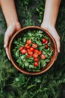 Hands Holding a Bowl of Salad with Tomatoes photo