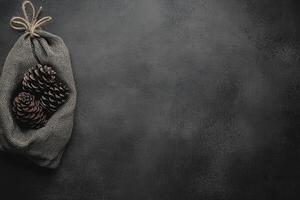 Pine Cones in a Burlap Sack on a Dark Gray Surface photo
