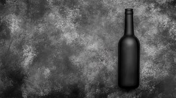 Black Wine Bottle Against a Gray Textured Background photo