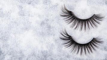 Pair of False Eyelashes on a Light Textured Background photo