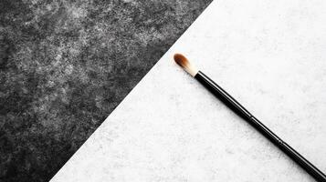Single Make up Brush on Textured Gray and White Background photo