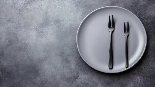 Elegant Black Forks on a Round Plate with Textured Gray Background photo