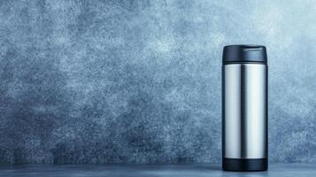 Silver Thermos Bottle on a Blue Textured Background photo