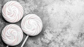 Three Swirled Lollipops on a Textured Grey Background photo