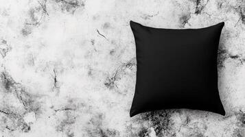 Black Square Pillow on Mottled Concrete Surface, Top View photo