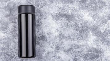 Black Thermos Bottle on Gray Textured Background photo