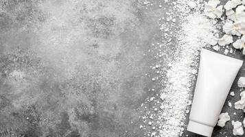 White Tube Surrounded by Scattered Powder and Petals on a Gray Surface photo