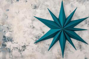 Teal Paper Starburst on a Weathered Gray Stone Surface in Soft Light photo