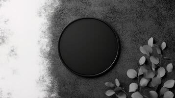 Minimalist Black Circle with Delicate Leaves on Textured Gray Surface photo