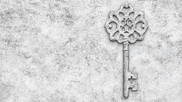 Ornate Vintage Key with Floral Design on Weathered Stone Surface photo