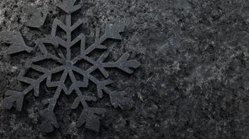 Intricate Black Snowflake Ornament on a Textured Dark Stone Surface photo