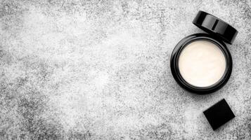 Open Black Jar of Creamy Substance on a Mottled Gray Stone Surface photo