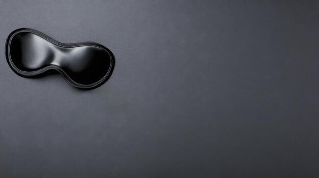 Sleek Black Sleep Mask on a Smooth Dark Gray Surface in Minimalist Style photo