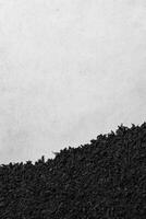Dark Loose Tea Leaves on a Light Textured Surface in Monochrome Contrast photo