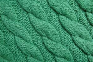 Green Cable Knit Fabric with Interwoven Stitches in a Textured Pattern photo