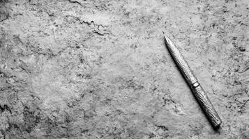 Silver Fountain Pen with Engraved Pattern on a Textured Grayscale Stone Surface photo