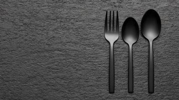 Black Fork and Spoon on a Textured Grayscale Stone Surface photo