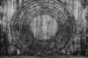 Intricate Circular Carving on a Weathered Wooden Surface in Monochrome photo