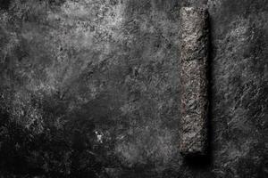 Ancient Rolled Parchment on a Textured Dark Grey Surface in Monochrome photo