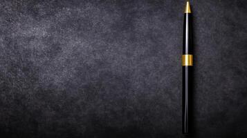Sleek Black Pen with Gold Accent on a Textured Dark Gray Surface photo