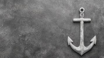Weathered White Anchor on a Textured Dark Gray Surface in Monochrome photo