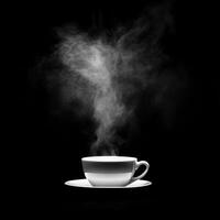 White porcelain cup emitting swirling steam on a dark background photo