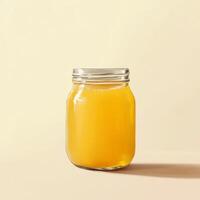 Glass Mason Jar Filled with Bright Orange Liquid on Pale Yellow Surface photo