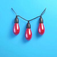 Three Matte Red Festive Bulbs Hanging on Black Wire Against Blue Surface photo