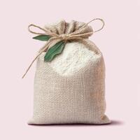 Rustic Burlap Sack Filled with White Powder Tied with Twine and Leaves photo
