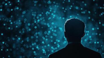 Silhouette of User Against Glowing Background Representing Encrypted Data Stream in Blue photo