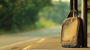 Urban Backpack Placed on Sidewalk Near Roadway Surrounded by Lush Greenery and Soft Morning Light photo