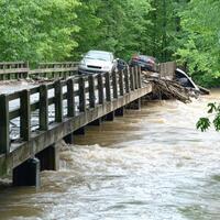 Collapsed Bridge Over Rushing River with Submerged Cars photo