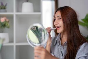 Glamour and Smile Transformation. Applying lip balm for a fresh and radiant look in front of the mirror. photo