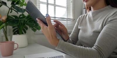 Technology and Communication. A person using a tablet while working from their organized desk. photo