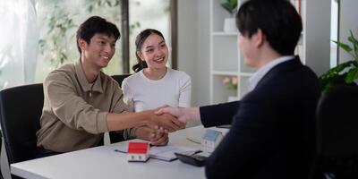 Successful Negotiation and Closing. A couple and their real estate agent finalize the home buying process. photo