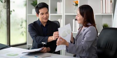 Professional Interaction and Financial Reporting. Colleagues exchanging insights while reviewing financial materials. photo