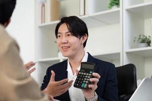 Professional Guidance in Real Estate Transactions. A smiling agent explaining investment options using a calculator. photo