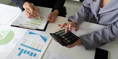 Collaborative Analysis and Reporting. A business team conducting calculations and reviewing data reports. photo