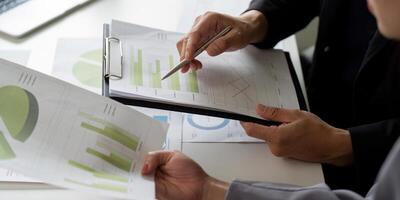 Collaboration and Data Analysis. Colleagues reviewing business reports and graphs together to enhance decision-making. photo
