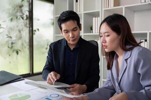Financial Insights and Teamwork. Colleagues collaborating on financial reports in a bright office. photo