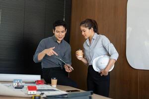 Casual Meeting Over Project Plans. Engineers enjoy coffee while discussing architectural projects. photo