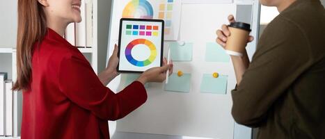 Creativity and Collaboration. A designer presenting color palettes on a tablet during a brainstorming session. photo