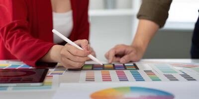 Creative Collaboration and Digital Design. A designer using a tablet in a brainstorming session with color palettes. photo